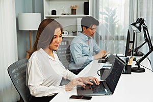 Beautiful IT developer analyzing program application beside coworker. Infobahn.