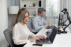 Beautiful IT developer analyzing program application beside coworker. Infobahn.