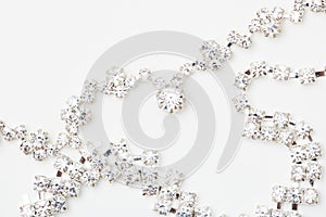 A beautiful diamond halo and white gold pendant dangles from a chain. Fine Jewelry necklace isolated on a white