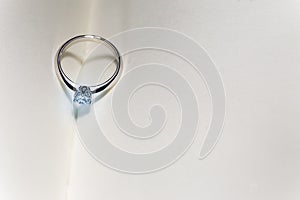 beautiful diamond ring on blank open book with heart shape shadow