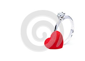 Beautiful diamond ring and a red felt heart on white background