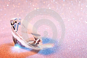 Beautiful diamond on shiny pink background, closeup. Space for text