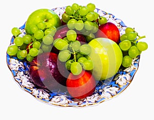 Beautiful dish covered with blue with gilded patterns with fruit - apples, grapes and peachesBeautiful dish covered with blue with