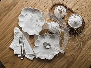 Beautiful dishes on a wooden table - dessert plates, cutlery, teapot, top view