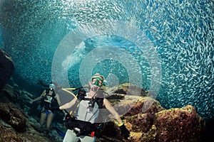 Beautiful diver in fish and corals reef background