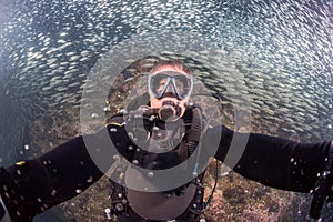 Beautiful diver in fish and corals reef background