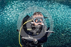 Beautiful diver in fish and corals reef background