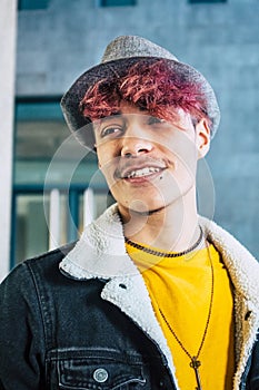 Beautiful diversity young people concept with caucasian cheerful coloured hair teenager male with urban wall in background -