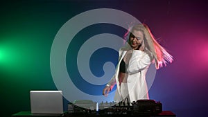 Beautiful dj girl in white jacket playing music