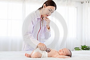 Beautiful doctor hand using stethoscope examining adorable infant heart, asian newborn baby get sick sleep during examine by