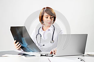 Beautiful doctor looking at x-ray scan in office