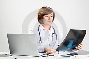 Beautiful doctor looking at x-ray scan in office