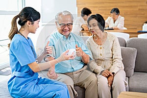 Beautiful doctor or nurse use blood pressure machine to measure and check health of senior man and his wife sit beside also look