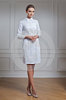 Beautiful doctor in white clothes. Portrait of attractive medic in white robe