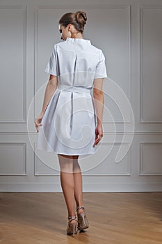 Beautiful doctor in white clothes. Portrait of attractive medic in white robe