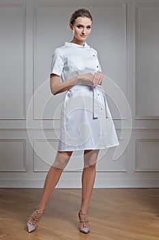 Beautiful doctor in white clothes. Portrait of attractive medic in white robe