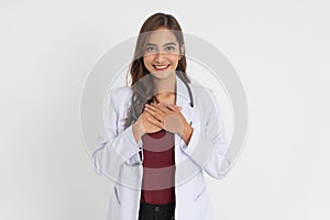 beautiful doctor in white uniform holding chest and smiling with patient expression