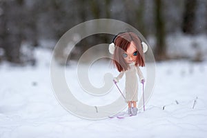 Beautiful, doll blythe, standing on skis, purple hair and winter clothes.
