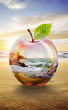 Beautiful double exposure image that combines a beach at sunrise and a glass apple.