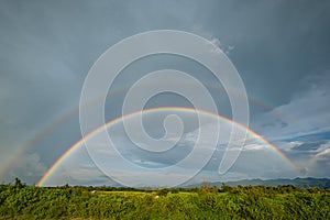 Beautiful double rainbow on clouds  rainy day in rice field. after rain concept fresh air