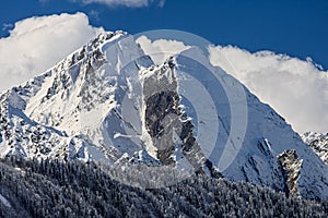 Beautiful dramatic snowy Caucasus mountain peaks and blue sky with clouds scenic winter landscape. West Caucasus. Sochi, Russia