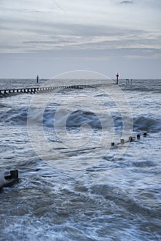 Beautiful dramatic stormy landscape image of waves crashing onto