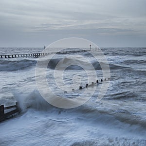 Beautiful dramatic stormy landscape image of waves crashing onto