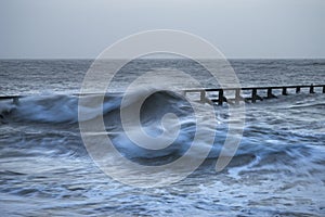 Beautiful dramatic stormy landscape image of waves crashing onto