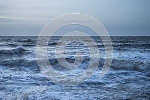 Beautiful dramatic stormy landscape image of waves crashing onto