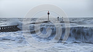 Beautiful dramatic stormy landscape image of waves crashing onto