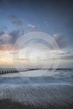 Beautiful dramatic stormy landscape image of waves crashing onto