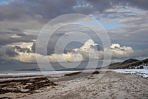 Beautiful dramatic unusual Winter landscape of snow on Embleton Bay beach in Northumberland England