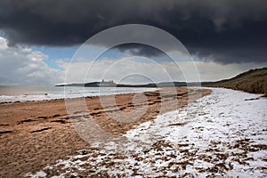 Beautiful dramatic unusual Winter landscape of snow on Embleton Bay beach in Northumberland England