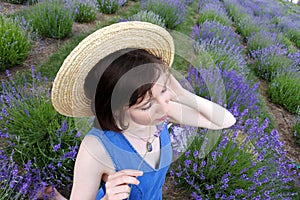 Beautiful dreaming girl among lavender flowers.