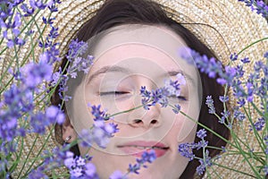 Beautiful dreaming girl among lavender flowers. Closeup portrait.