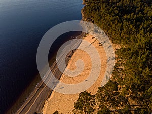 Beautiful drone areal photography view of large dune and pine forest near river Lielupe. Photo taken on sunset