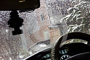 beautiful drops of water on the windshield of the car with the glass cleaners turned on, during a thunderstorm and rain in the