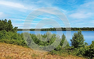 Beautiful dutch maas dunes landscape, blue lake water, green forest along hiking and cycle trail - Maasduinen NP, Reindersmeer,