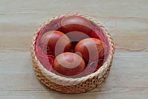 Beautiful dyed chicken eggs lie in wicker basket