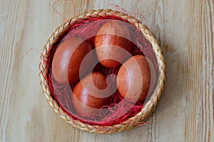 Beautiful dyed chicken eggs lie in wicker basket