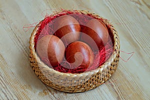 Beautiful dyed chicken eggs lie in wicker basket