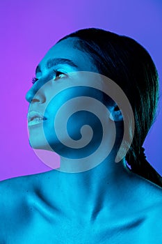 Beautiful east woman portrait isolated on gradient studio background in neon light, monochrome