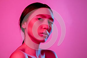 Beautiful east woman portrait isolated on pink studio background in neon light, monochrome