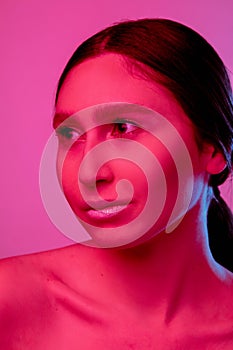 Beautiful east woman portrait isolated on pink studio background in neon light, monochrome