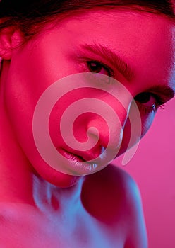 Beautiful east woman portrait isolated on pink studio background in neon light, monochrome