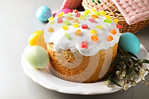 Beautiful Easter cake and painted eggs on light grey table