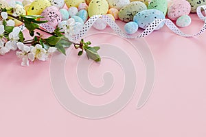 Beautiful Easter card with colorful eggs and cherry branches on paper pink background