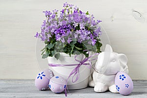 Beautiful easter decoration with Campanula flowers, Easter eggs and ceramic rabbit
