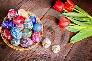 Easter eggs with tulips on weathered wooden background