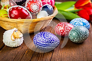 Easter eggs with tulips on weathered wooden background